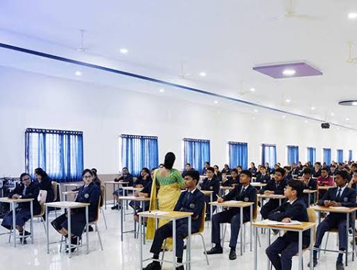 Invigilator distributing question papers at the start of an exam